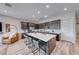 Modern open kitchen with a large island with white countertop, stainless steel appliances, and bar stool seating at 109 Reverie Heights Ave, Henderson, NV 89011