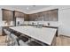 Modern kitchen featuring a large island with seating, stainless steel appliances, and stylish dark wood cabinetry at 109 Reverie Heights Ave, Henderson, NV 89011