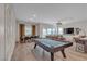 Bright living room with a pool table, a dining table, sliding glass doors to the patio, and a modern entertainment center at 109 Reverie Heights Ave, Henderson, NV 89011