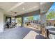 Spacious covered patio with dining and lounging areas, complemented by an outdoor kitchen and fireplace at 109 Reverie Heights Ave, Henderson, NV 89011