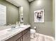 Stylish powder room features modern fixtures, a large mirror, and unique artwork, adding character at 109 Reverie Heights Ave, Henderson, NV 89011