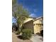 Tan two-story home with a two car garage featuring desert landscaping and a sunny, cloud-strewn sky at 1205 Padre Serra Ln, Las Vegas, NV 89134