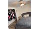 Cozy bedroom featuring a bed with a gray cushioned headboard, fan and closet with clothes at 1305 Shenandoah St, Boulder City, NV 89005