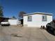 Exterior view of a single story home with white siding, grey trim and an adjacent garage with a vintage car at 1305 Shenandoah St, Boulder City, NV 89005