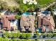 An aerial view of multiple homes and a street with lush trees surrounding the properties at 15 Vintage Canyon St, Las Vegas, NV 89141