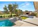 Relaxing backyard featuring a pool, lounge chairs, and outdoor kitchen with golf course views at 15 Vintage Canyon St, Las Vegas, NV 89141