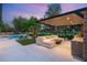 Enjoy the evening in the backyard featuring a pool, outdoor kitchen, and comfortable lounge area with golf course views at 15 Vintage Canyon St, Las Vegas, NV 89141