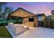 Comfortable backyard featuring an outdoor kitchen, TV, lounge area, and golf course views at dusk at 15 Vintage Canyon St, Las Vegas, NV 89141