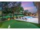 View of a pristine backyard featuring a pool, lounge chairs, and putting green at 15 Vintage Canyon St, Las Vegas, NV 89141