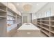 Bright walk-in closet features custom shelving, an island, and a stylish chandelier at 15 Vintage Canyon St, Las Vegas, NV 89141