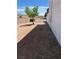 Side yard features dirt landscaping, with gravel and a tree at 158 Greenbriar Townhouse Way, Las Vegas, NV 89121