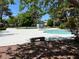 Community pool featuring a calming atmosphere with abundant trees and nearby seating at 158 Greenbriar Townhouse Way, Las Vegas, NV 89121