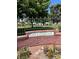Decorative Greenbriar sign amidst a brick wall and vibrant flower bed at 158 Greenbriar Townhouse Way, Las Vegas, NV 89121