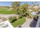 A charming backyard features a pristine lawn, a patio with an outdoor dining set, and a view of a lush golf course at 1613 Iron Ridge Dr, Las Vegas, NV 89117