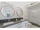 Modern bathroom with dual sinks, mirrors and a glass-enclosed shower at 1613 Iron Ridge Dr, Las Vegas, NV 89117