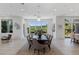 Spacious dining room features sleek table, neutral chairs and golf course views through the large window at 1613 Iron Ridge Dr, Las Vegas, NV 89117