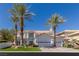 Luxury two-story home with a three car garage and palm trees at 1613 Iron Ridge Dr, Las Vegas, NV 89117