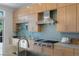 Close-up of the kitchen showing updated appliances, glass tile backsplash and light wood cabinetry at 1613 Iron Ridge Dr, Las Vegas, NV 89117