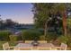 Outdoor dining area showcases golf course views with lush landscaping and an elegant table setting at 1613 Iron Ridge Dr, Las Vegas, NV 89117