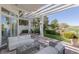Outdoor patio with elegant white furniture, pergola and manicured garden overlooking the golf course at 1613 Iron Ridge Dr, Las Vegas, NV 89117