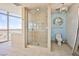 Modern bathroom features a glass enclosed shower, toilet, and a large window overlooking the city at 200 W Sahara Ave # 2407, Las Vegas, NV 89102