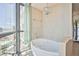 A bathroom with a garden tub next to a window with a view of the city at 200 W Sahara Ave # 2407, Las Vegas, NV 89102