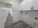 This laundry room offers white cabinets and sleek black hardware for a modern look at 2201 W Wisteria Way, Pahrump, NV 89048