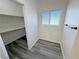 Bright walk-in closet features wood-look tile flooring, metal storage shelving and a window at 2201 W Wisteria Way, Pahrump, NV 89048