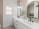 Elegant bathroom featuring double sinks, modern fixtures, decorative mirrors, and neutral tiling at 2317 Sierra Heights Dr, Las Vegas, NV 89134