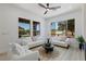 Bright living room featuring plush seating, large windows with backyard views, and a ceiling fan at 2317 Sierra Heights Dr, Las Vegas, NV 89134