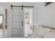 Comfortable main bedroom showcasing an en-suite bathroom, barn door, and closet with shelving at 2317 Sierra Heights Dr, Las Vegas, NV 89134