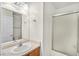 Clean bathroom featuring a single sink, a large mirror, and a tub with frosted glass doors at 2509 April Breeze Ln, Henderson, NV 89002