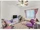 Bedroom with ceiling fan, window, and bed with purple chair, and a cluttered desk at 2509 April Breeze Ln, Henderson, NV 89002