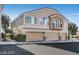 Exterior view of the townhome, featuring three garages and small balcony at 2509 April Breeze Ln, Henderson, NV 89002