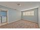 Neutral bedroom with carpeted floors, blue walls, and window letting in natural light and a laundry room through the door at 2708 Bello Dr, North Las Vegas, NV 89030