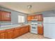 Traditional kitchen with wooden cabinets, tile countertops, and white appliances at 2708 Bello Dr, North Las Vegas, NV 89030