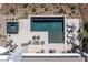 An aerial view of a modern backyard with a pool, spa, firepit, lounge chairs, and landscaped yard at 29 Falling Ridge Ln, Henderson, NV 89011