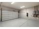 Clean and organized garage with a large door, epoxy flooring, and modern fixtures at 29 Falling Ridge Ln, Henderson, NV 89011