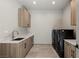 Functional laundry room with sleek washer and dryer, ample counter space, and custom wood cabinets at 29 Falling Ridge Ln, Henderson, NV 89011