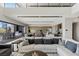 Open floor plan showcasing living room with plush sectional sofa, extending to an outdoor dining area at 29 Falling Ridge Ln, Henderson, NV 89011