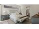 A well-lit main bedroom features a cozy bed with an patterned bench and views into the bathroom at 29 Falling Ridge Ln, Henderson, NV 89011