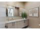 Elegant powder room featuring a stone countertop, patterned accent wall, and modern fixtures at 29 Falling Ridge Ln, Henderson, NV 89011
