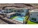 This home's backyard oasis features a pool, lounge area, covered outdoor dining and desert landscaping at 302 Watteau Ct, Henderson, NV 89012