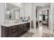 Bathroom featuring dual vanities, dark cabinets, and a large mirror at 302 Watteau Ct, Henderson, NV 89012