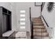 Welcoming entryway with a coat rack, storage bench, and staircase with safety gate at 302 Watteau Ct, Henderson, NV 89012