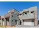 Beautiful, modern gray multi-story home featuring a 2-car garage, desert landscape, and sleek architecture at 302 Watteau Ct, Henderson, NV 89012