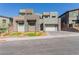 Contemporary gray home features stone accents, desert landscaping, and a two-car garage at 302 Watteau Ct, Henderson, NV 89012