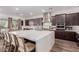 Modern kitchen features an oversized island and stainless appliances with dark cabinets at 302 Watteau Ct, Henderson, NV 89012
