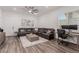 Cozy living room with a brown sectional sofa, wood flooring, and a ceiling fan at 302 Watteau Ct, Henderson, NV 89012