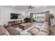 Living room boasts a large sofa, entertainment center, and seamless indoor-outdoor flow at 302 Watteau Ct, Henderson, NV 89012
